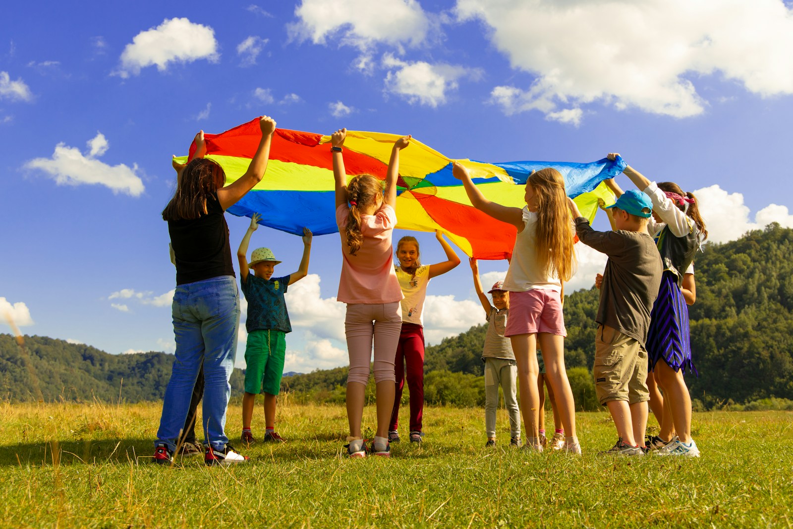 Children playing together with a colourful parachute